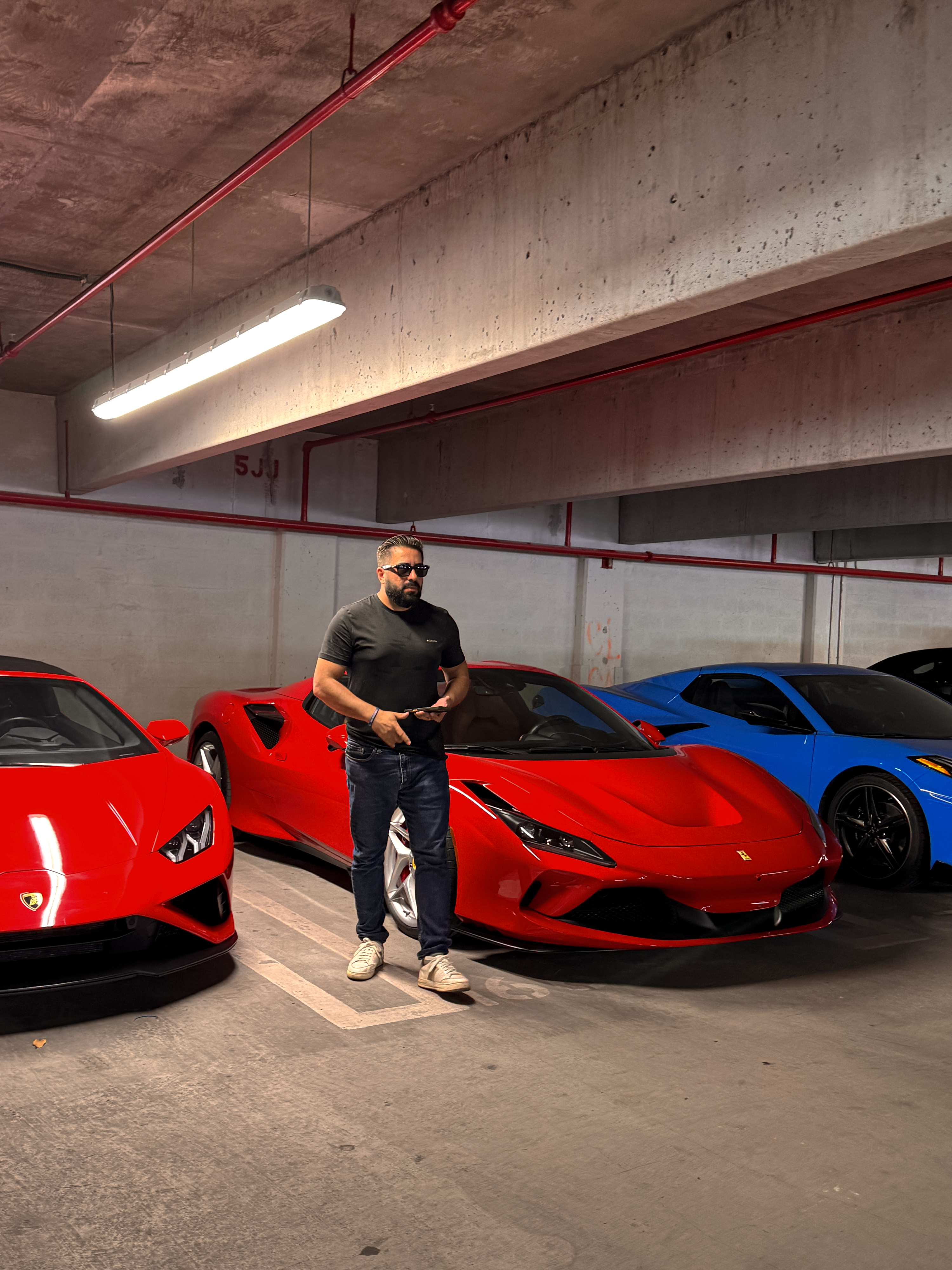 Bruno de Souza, founder of RentalCore OS, standing between vehicles in a fleet garage